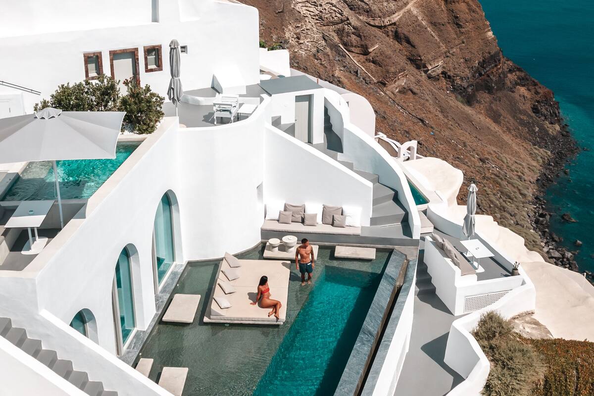 A modern white building with a pool and a view of the sea.