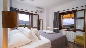 Un dormitorio con cama, una silla y vistas a las montañas.