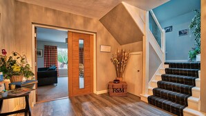 Un vaste espace de vie doté d’un plancher en bois, d’un escalier et d’une vue sur la salle à manger.