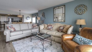 A living room with two sofas, a coffee table, and a lamp. - Yacht Club S #1-1001b 2 Bedroom Condo by RedAwning (North Myrtle Beach)