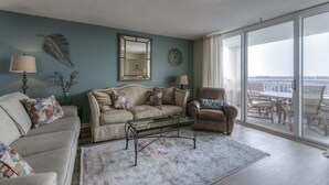 A living room with a sofa, armchairs, a coffee table, and a large window offering a view. - Yacht Club S #1-1001b 2 Bedroom Condo by RedAwning (North Myrtle Beach)