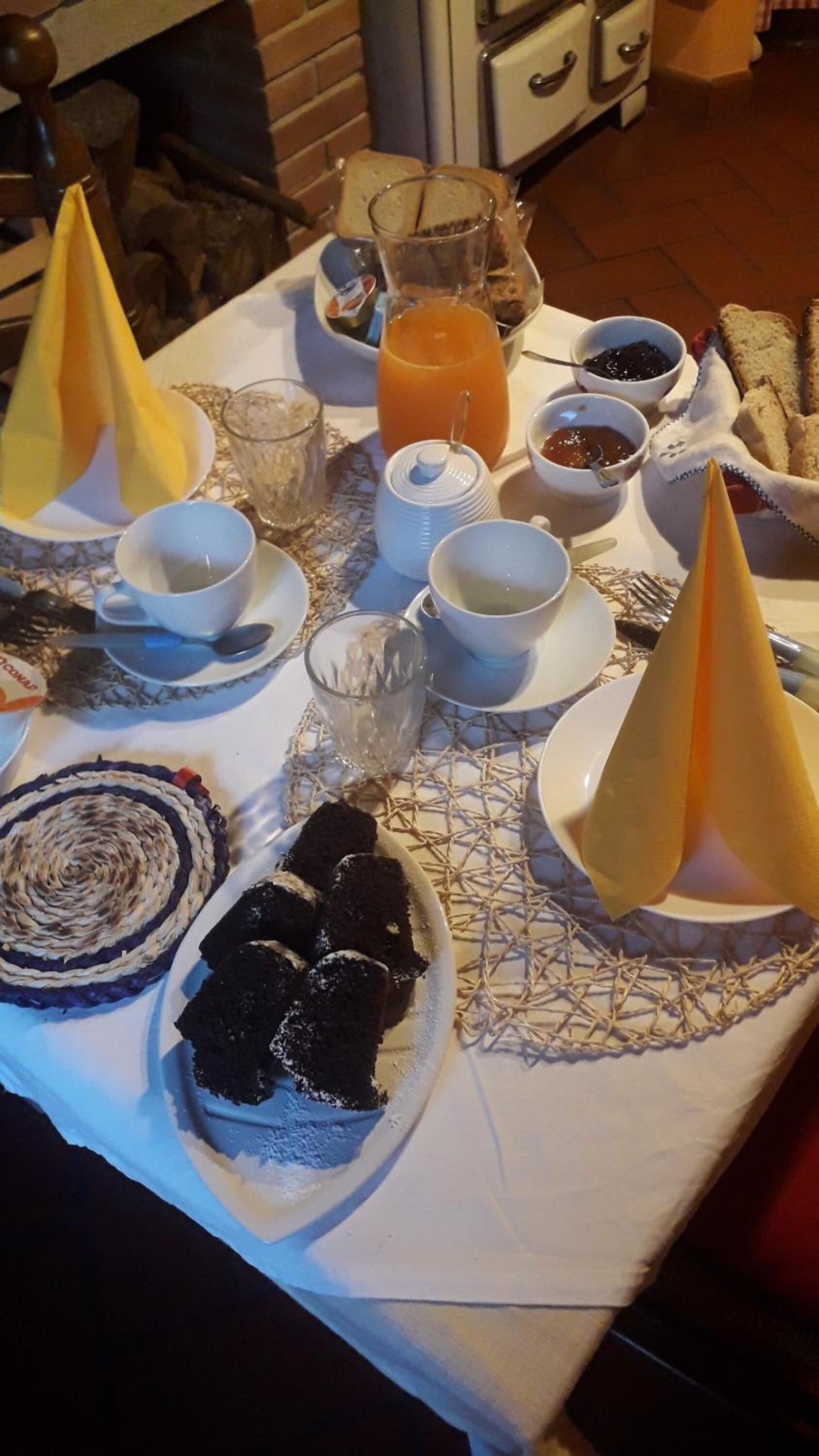 A breakfast table with various food items, including toast, jam, and a glass of orange juice.