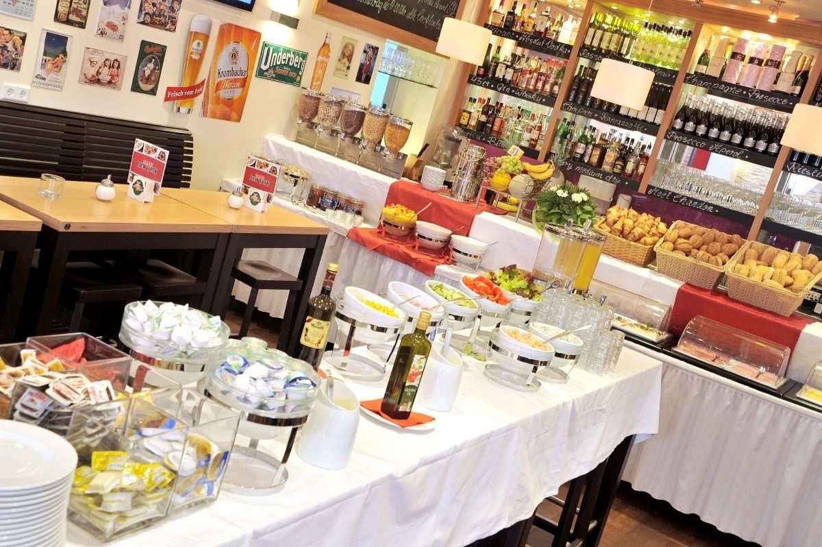 A buffet with various food items and a selection of wine bottles.