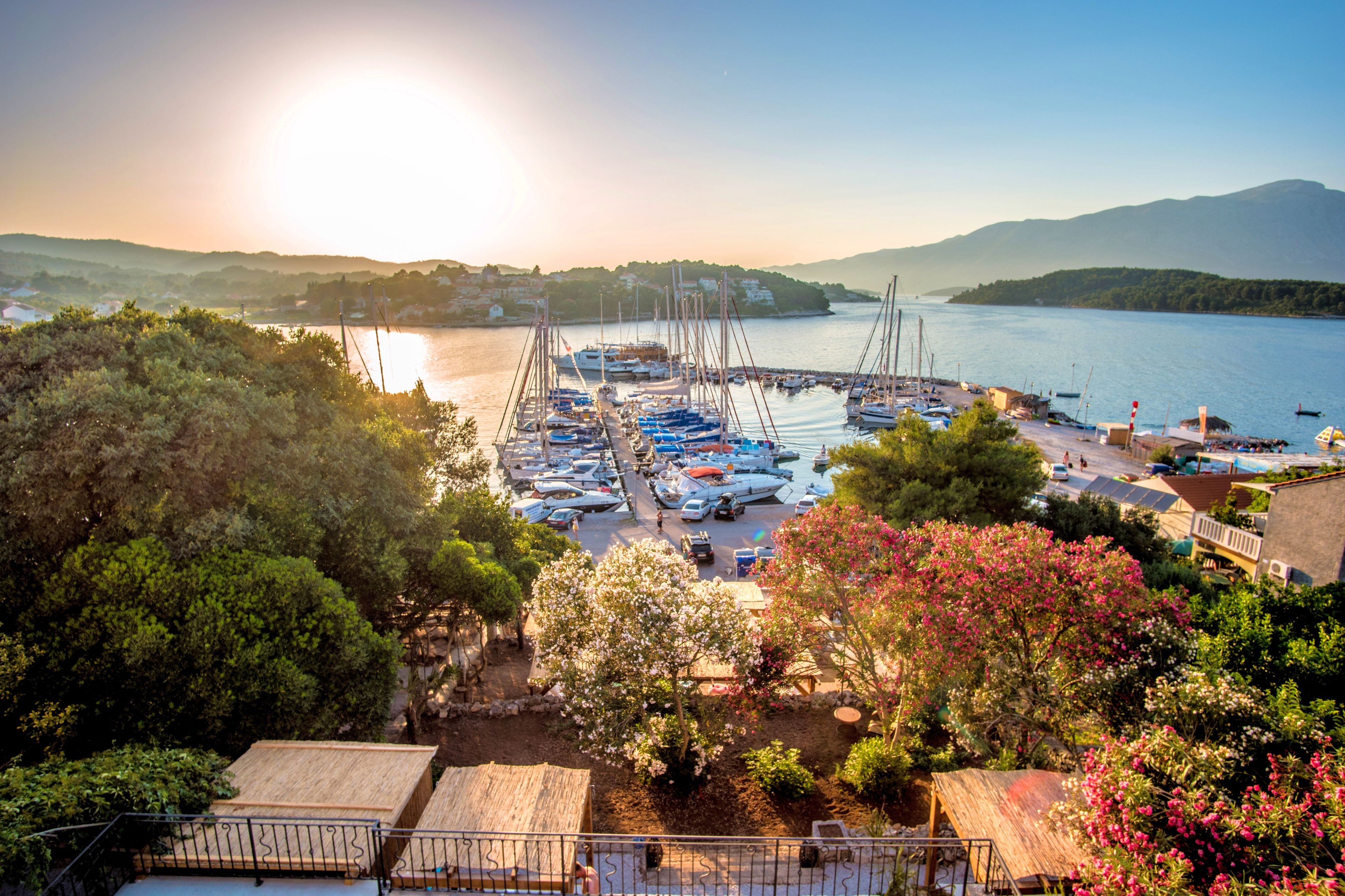 A marina with boats docked, surrounded by hills and trees.