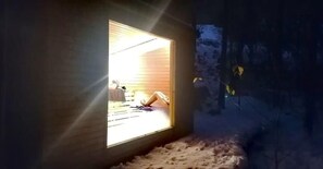 A room with a window, a bed, and a view of the outdoors.