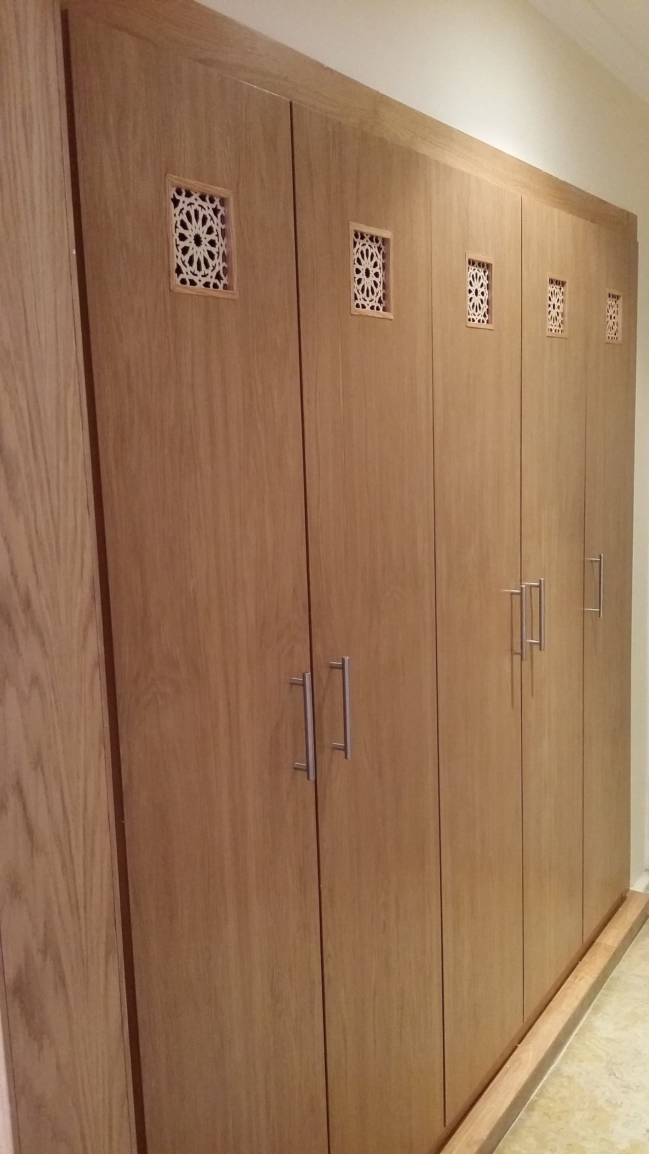 A large wooden wardrobe with multiple doors and decorative cutouts.
