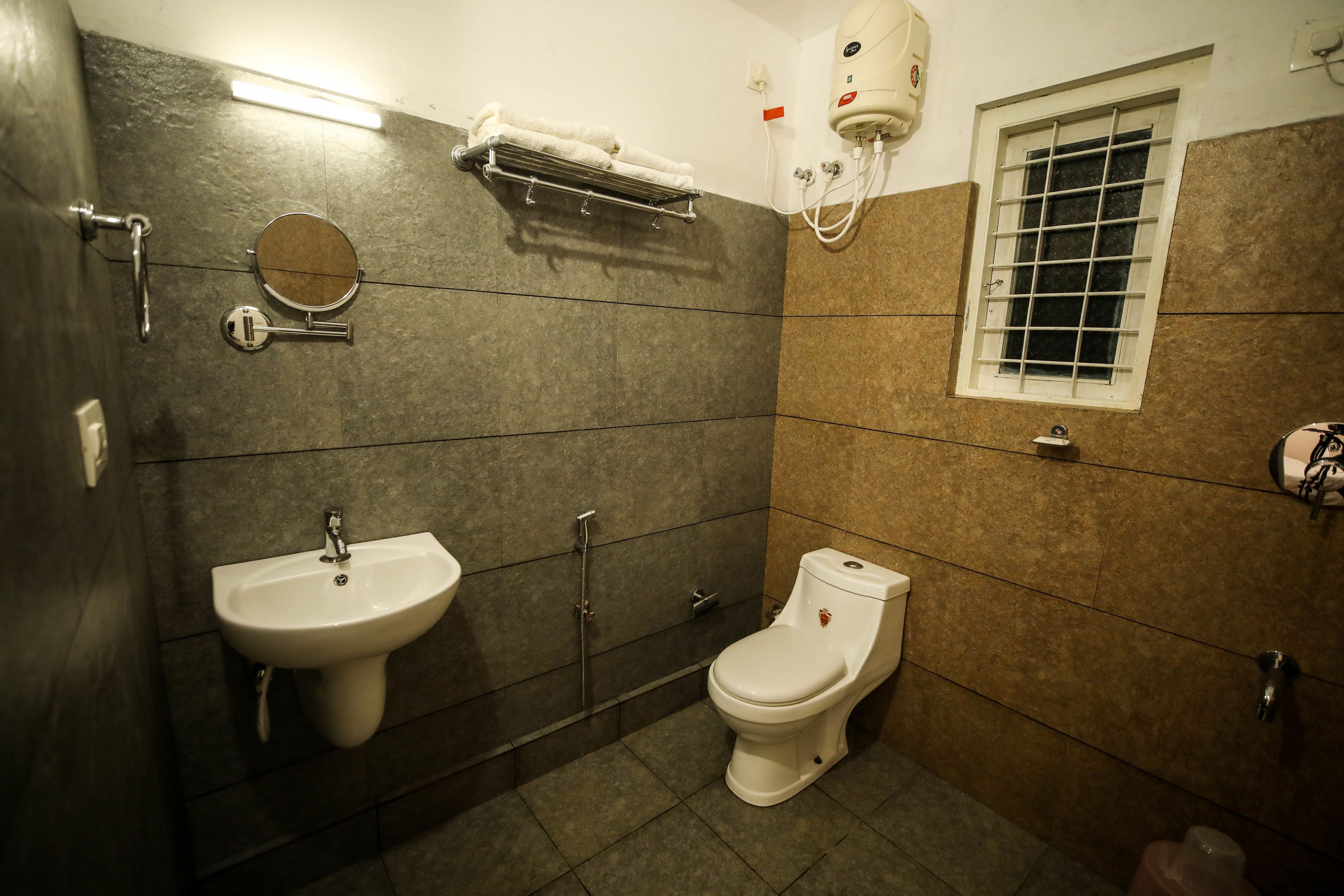 Un bagno con lavandino, WC e porta asciugamani.