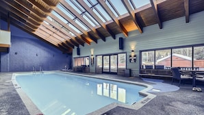 An indoor swimming pool with a wooden ceiling, large windows, and a lifeguard duty sign. - Mountainside 753 3 Bedroom Home by RedAwning (Frisco)