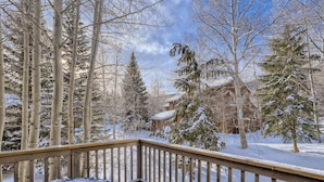 A snow-covered deck with a view of a cabin and trees. - Mountainside 753 3 Bedroom Home by RedAwning (Frisco)