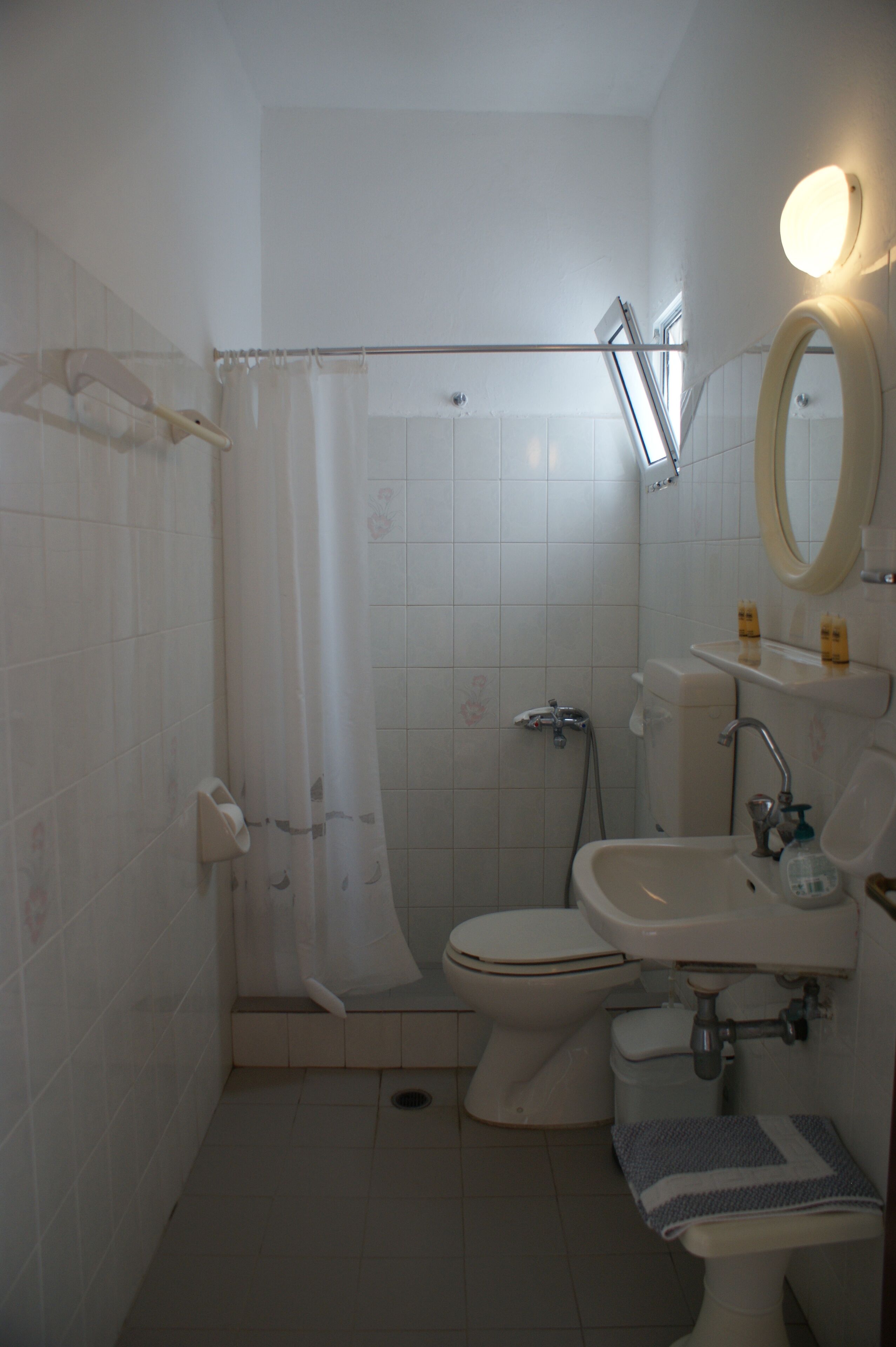 A bathroom with a toilet, sink, and shower curtain.