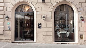 Fachada de edificio con dos ventanas arqueadas, un letrero que indica un restaurante llamado "Linea" y un símbolo de accesibilidad para sillas de ruedas.