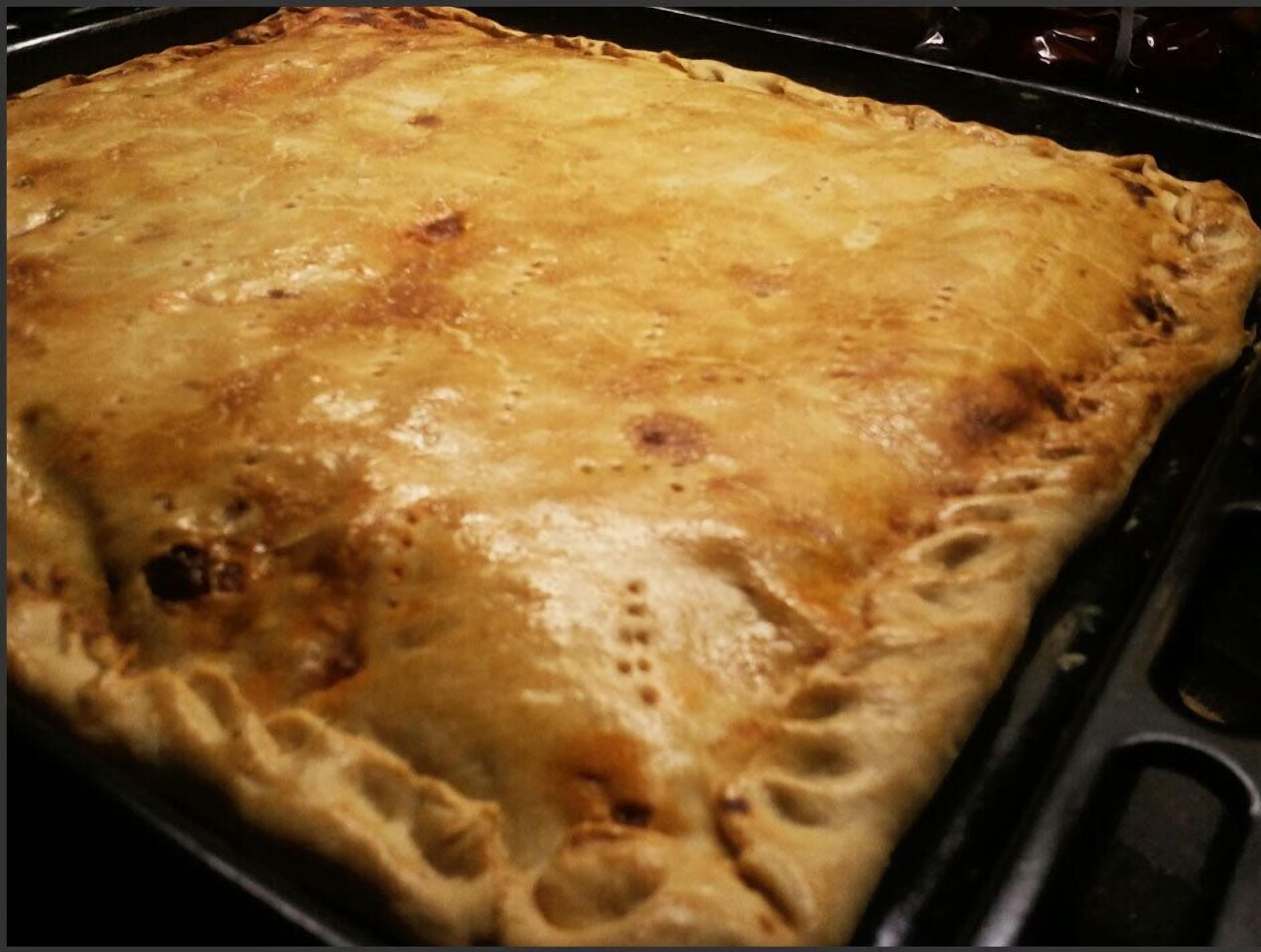 Eine große, rechteckige Auflaufform mit goldbrauner Kruste, vermutlich ein Auflauf oder Lasagne in einer Backform.