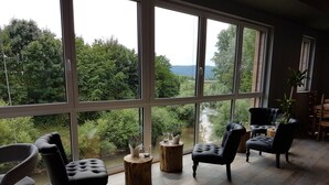 A room with large windows, wooden flooring, and black upholstered chairs. - Hotel Reich an der Rems (Schorndorf)