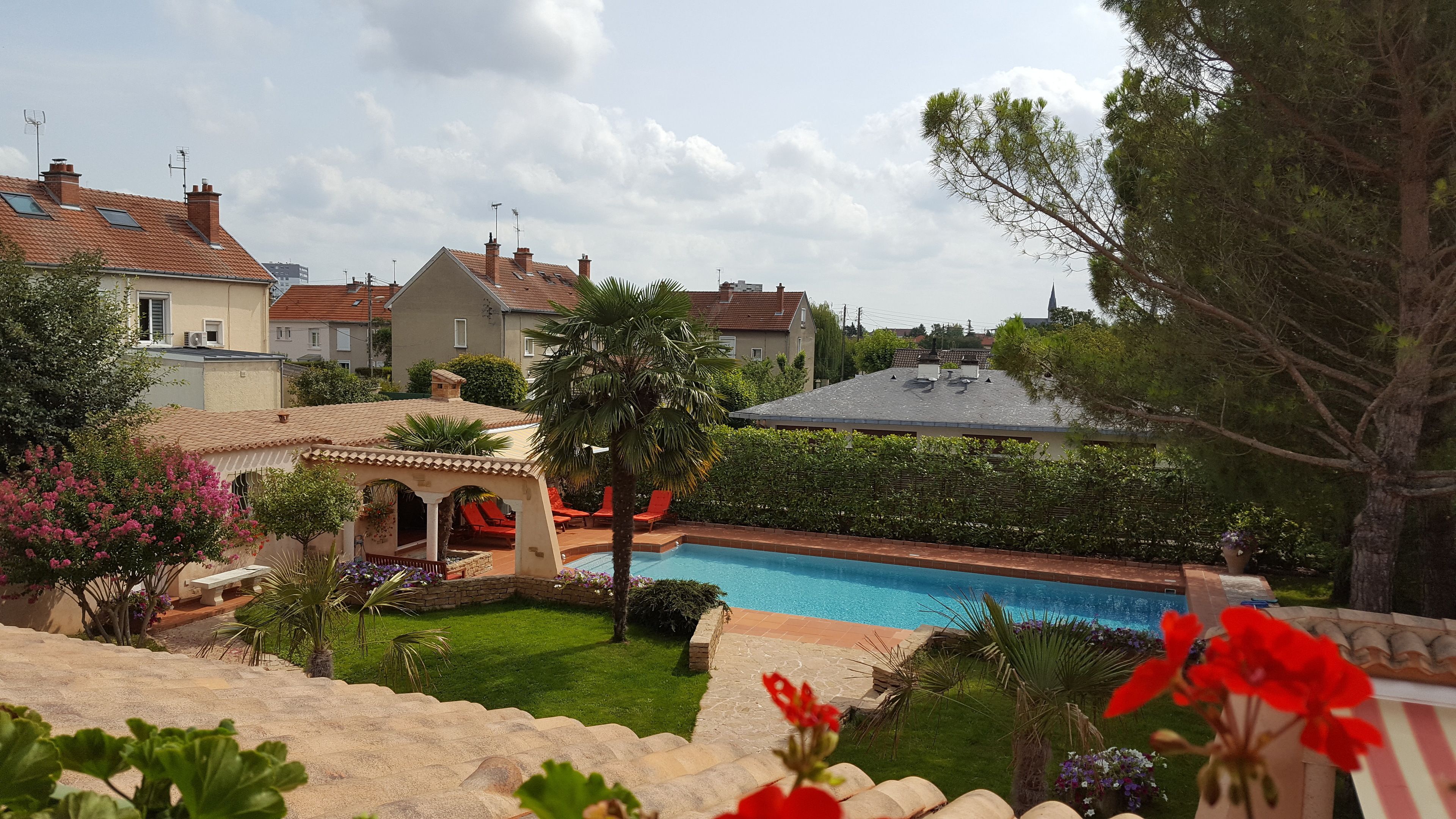 A residential area with a swimming pool, houses, and a gazebo.