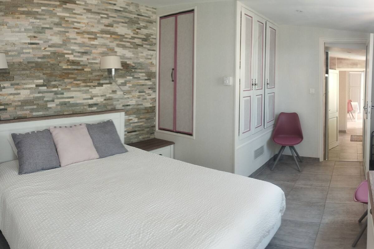 Une chambre à coucher avec un lit, une armoire, une chaise et une lampe.