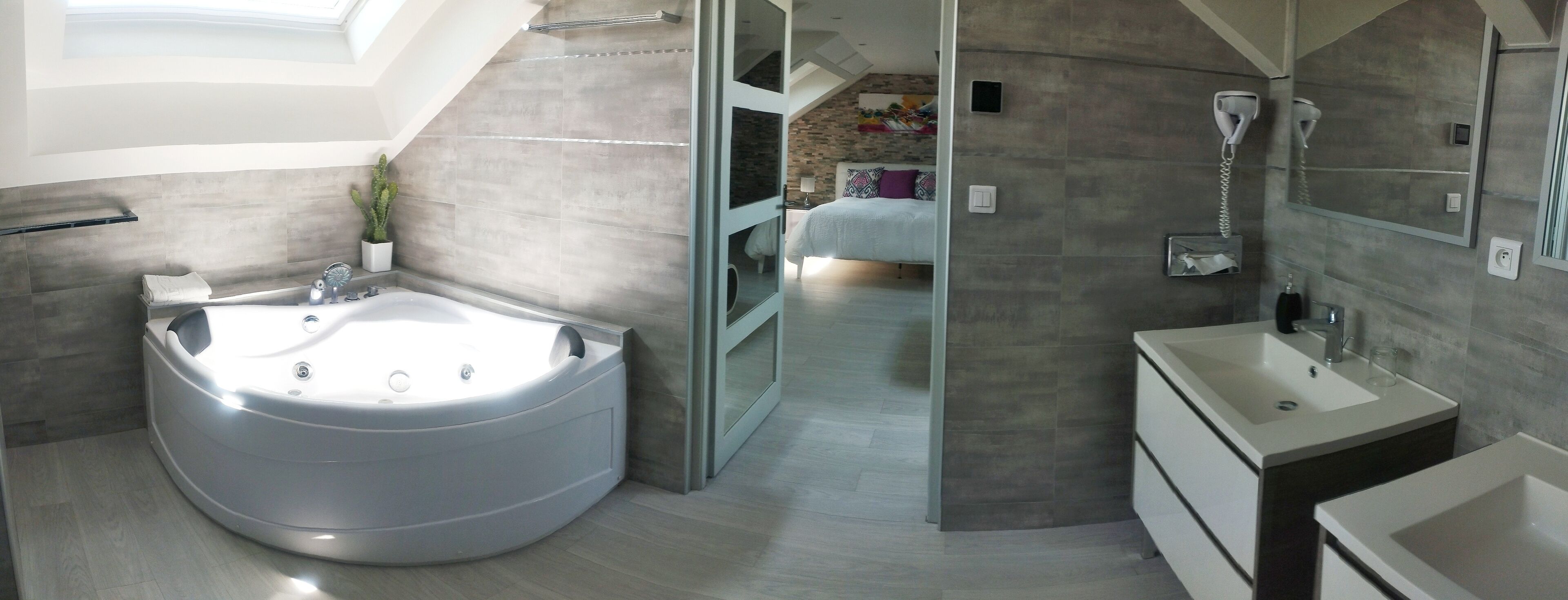 A modern bathroom with a large freestanding bathtub, a separate shower area, and a vanity with a sink.