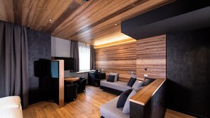 Een moderne kamer met houten plafond, een bank, een televisie en een bureau.
