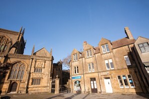 A historic building with Gothic architectural elements, including pointed arches and detailed stonework. - Abbey Court (Sherborne)