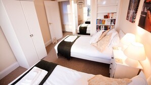 A bedroom with a bed, bedside tables, a bookshelf, and a wardrobe. - Abbey Court (Sherborne)