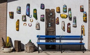 A wall with various decorative items, a blue bench, and a rustic door. - B&B Giuggiolando (L'Aquila)