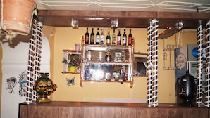 A bar area with wooden shelves holding bottles and a decorative vase. - Pegasus Hostel (Baku)