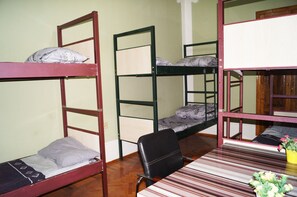 A dormitory room with bunk beds, a wooden desk, and a chair. - Pegasus Hostel (Baku)