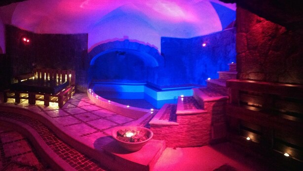 An indoor ice bath area with a stone bench and a fire pit. - B&B Villa Cinque Pini (Casamicciola Terme)