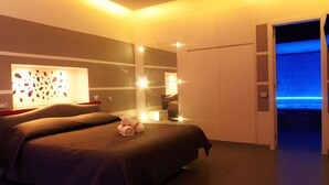 A modern hotel room with two beds, a large mirror, and a blue-lit door. - B&B Villa Cinque Pini (Casamicciola Terme)