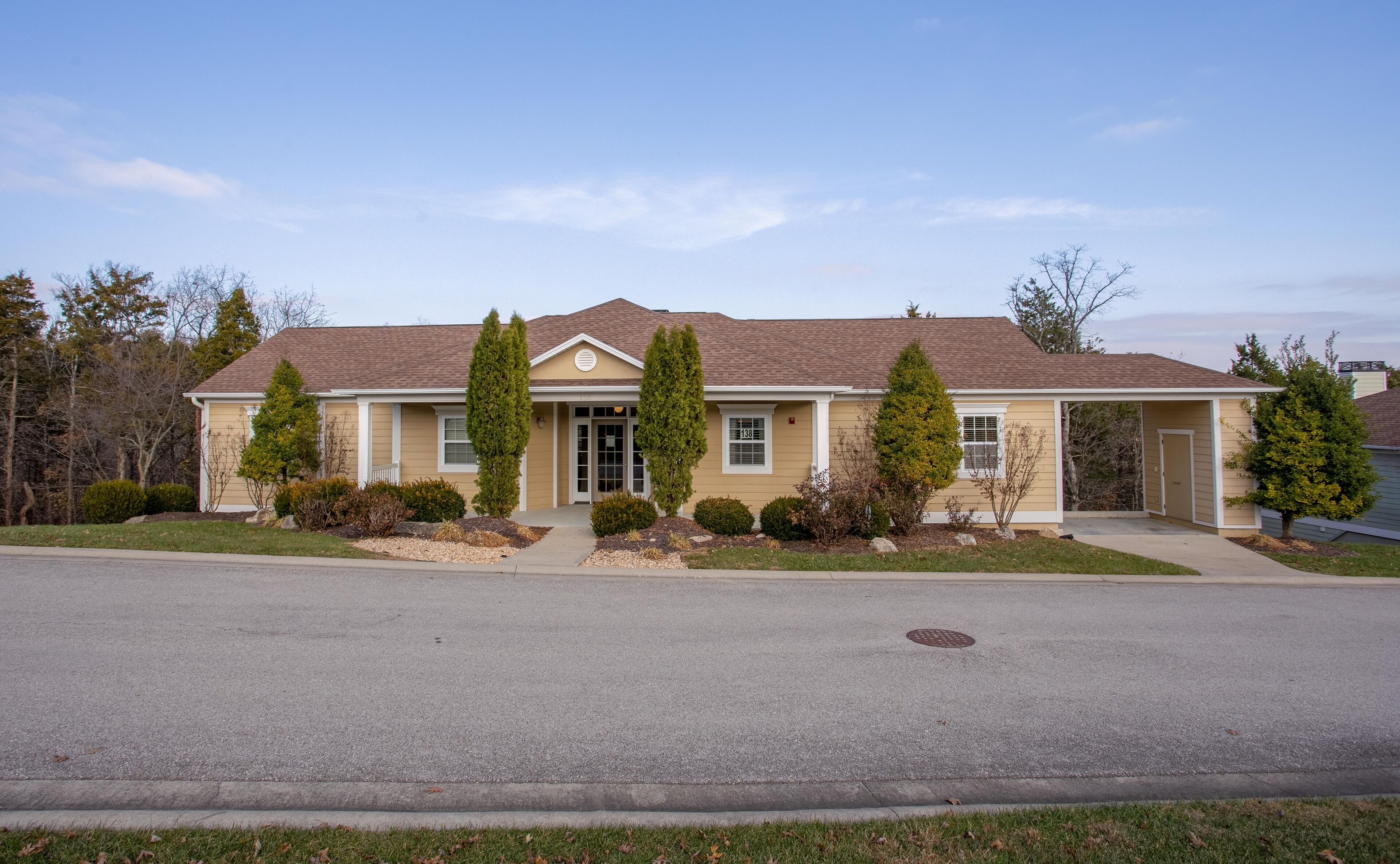 A two-story house with a front porch, a garage, and a well-maintained lawn.