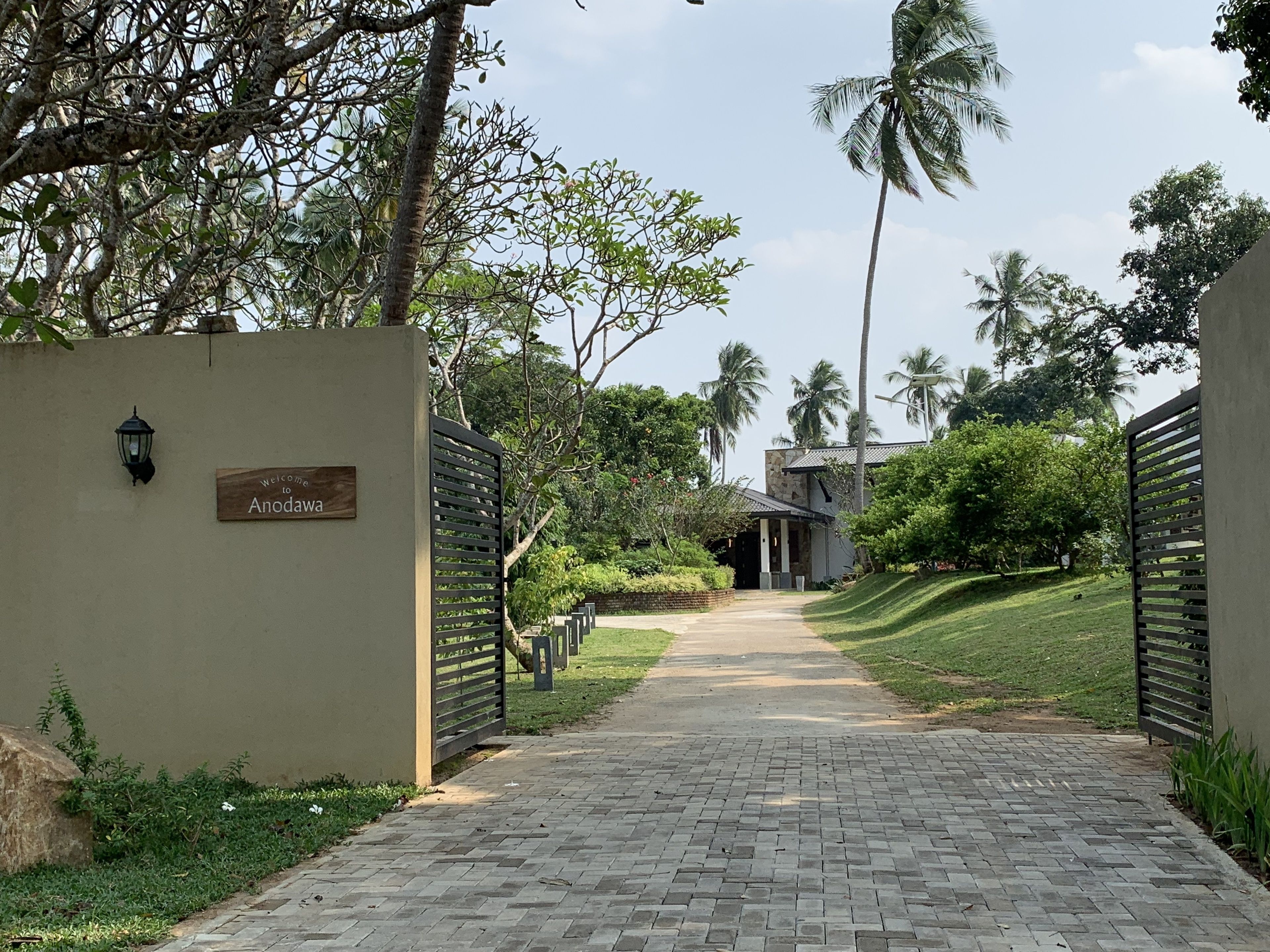 A paved pathway leading to a building with a sign reading "Welcome to Anodaw."