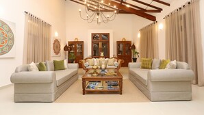 A living room with two sofas, a coffee table, and a chandelier.