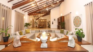 A spacious living area with a wooden coffee table, two sofas, and a chandelier.