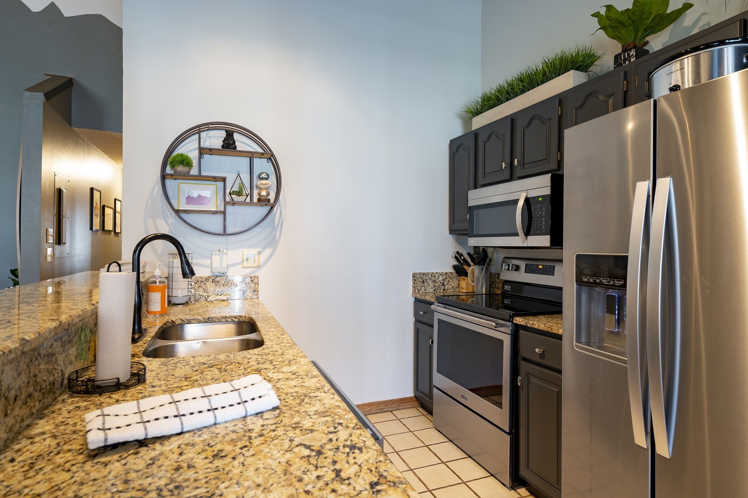 A modern kitchen with granite countertops, stainless steel appliances, and a built-in oven.