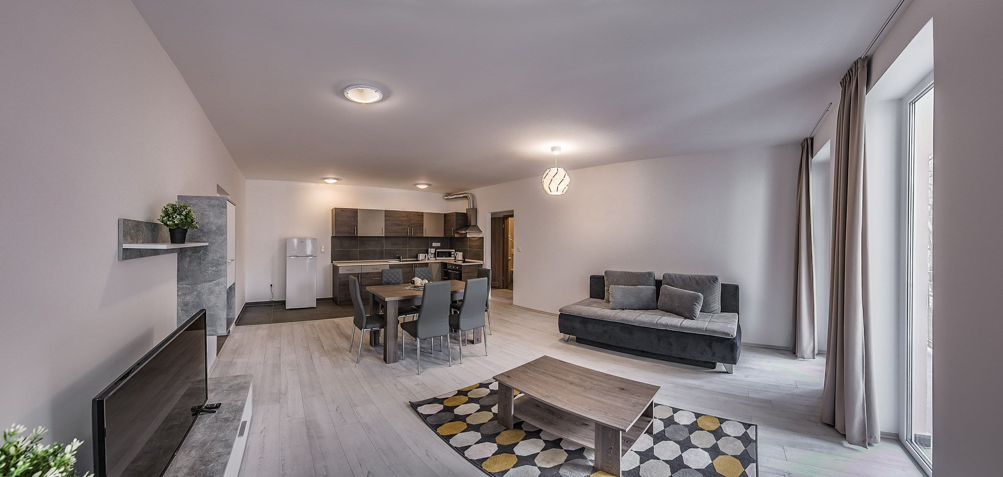 Ein modernes Wohnzimmer mit einer Couch, einem Couchtisch und einem Essbereich.