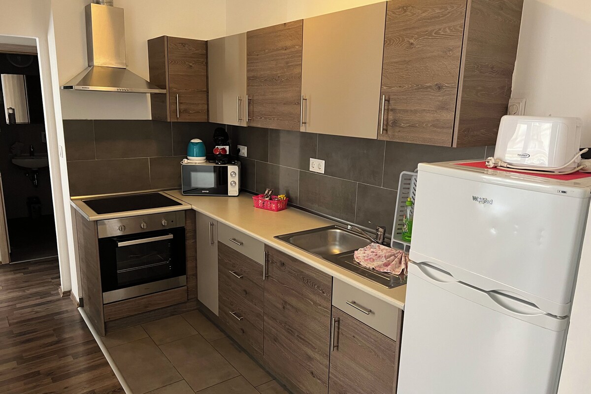 A modern kitchen with a built-in oven, microwave, and a white refrigerator.