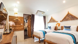 A hotel room with two beds, a wooden desk, a mirror, and a chandelier. - Anumat Premium Budget Hotel (Chiang Mai)