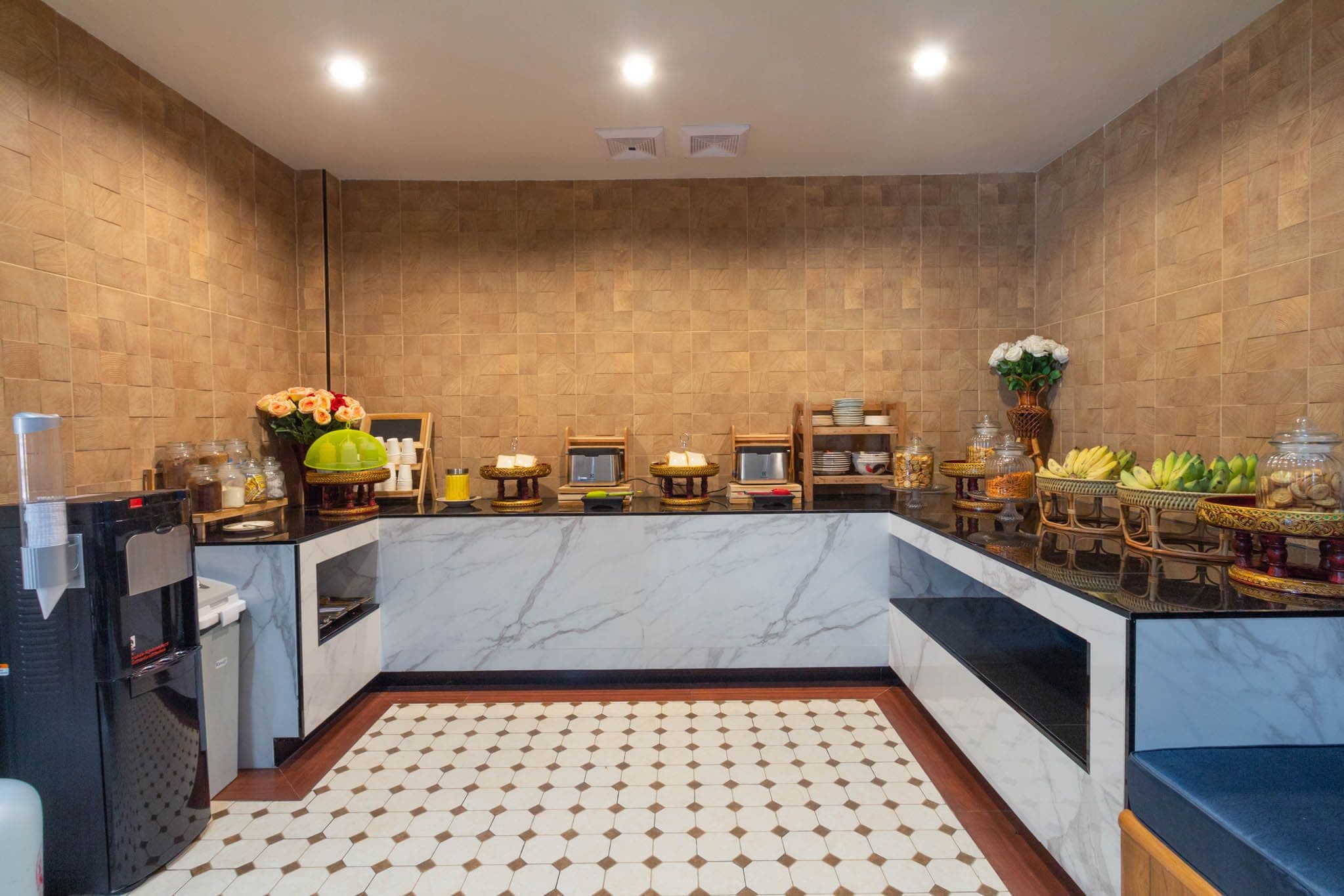 A modern kitchen with marble countertops, a central island, and a tiled floor.