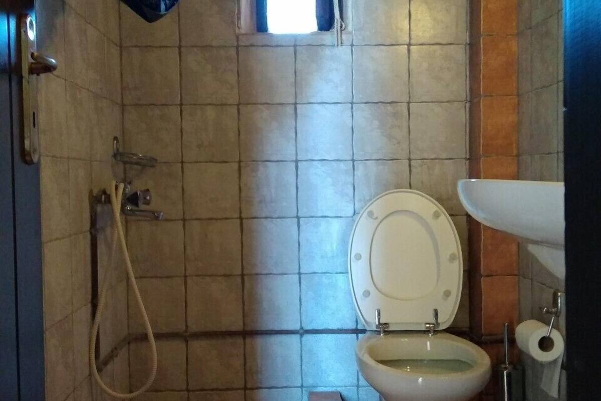 A small bathroom with a toilet, a shower, and a sink.