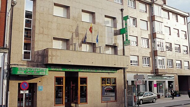 Un immeuble abritant plusieurs commerces, notamment un restaurant et une pharmacie.