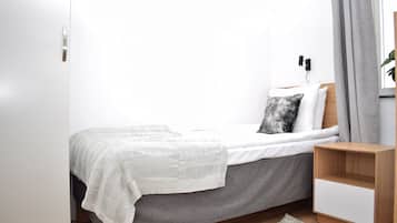 A minimalist bedroom with a bed, bedside table, and a nightstand.