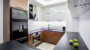 Uma cozinha moderna com frigorífico, forno e lava-loiça embutidos.