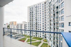 A high-rise residential building with multiple balconies, a rooftop garden, and a clear view of the surrounding urban area. - VISENTO Apartments Kaczorowskiego 7 (Bialystok)