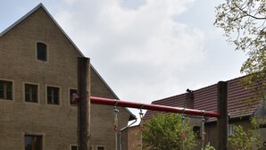 Een schommelset in een gazon met een gebouw op de achtergrond.
