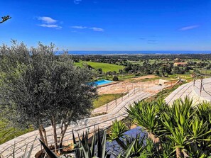 Una piscina al aire libre, sombrillas, sillones reclinables de piscina