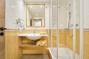A bathroom with a sink, mirror, and shower. - Das Appartmenthaus Silvia (Bad Fuessing)