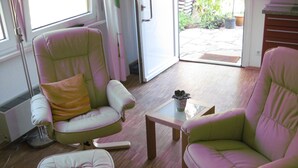 A room with two green chairs, a small table, and a window. - Ferienwohnung Schwahn (Herdwangen Schoenach)