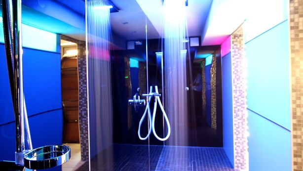 A modern shower area with a glass-enclosed design, a chrome showerhead, and a visible water stream. - Parkhotel Emstaler Höhe (Bad Emstal)