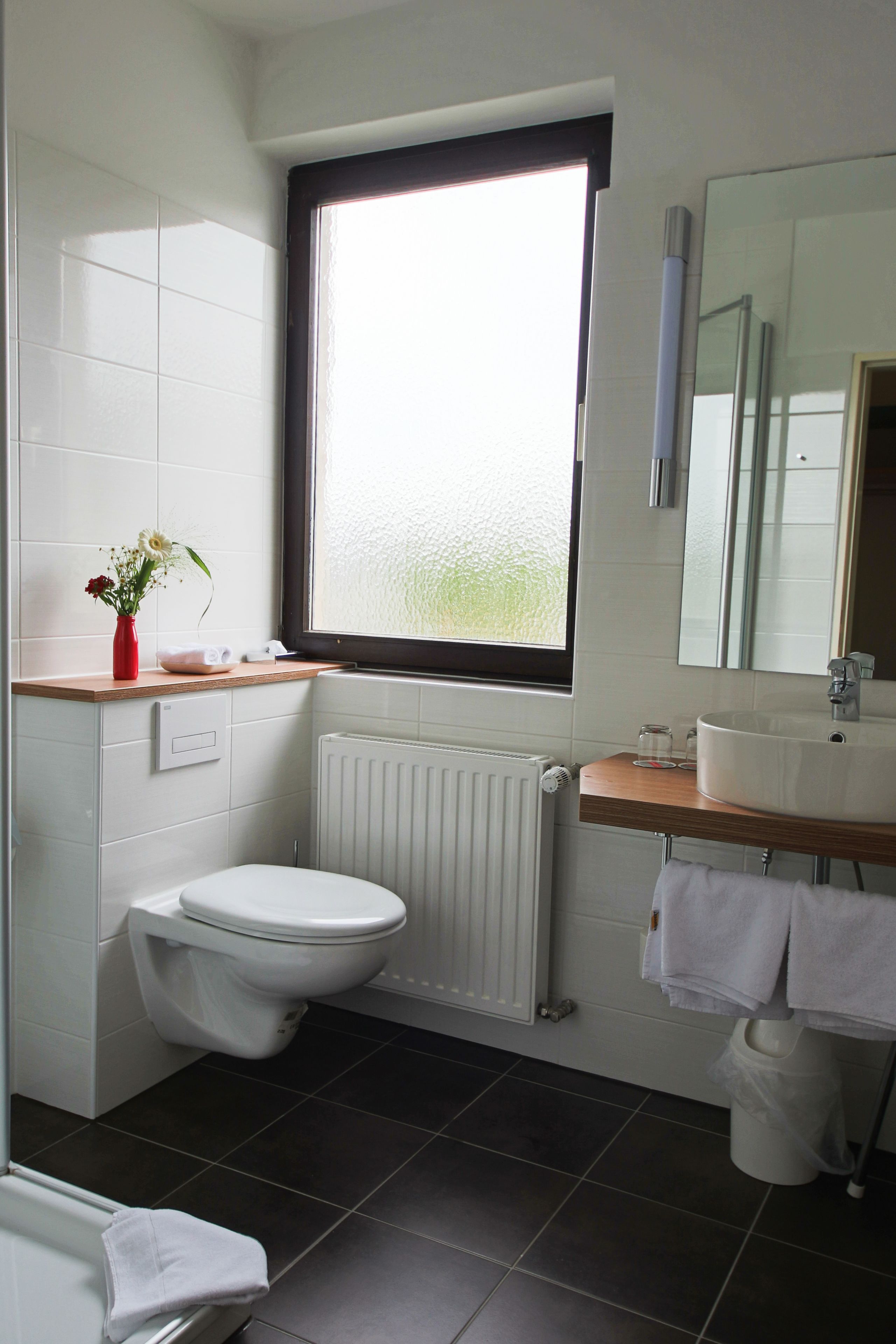Un baño moderno con inodoro, lavabo y ventana.
