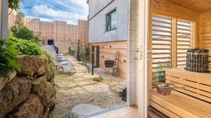A sauna area with a wooden bench and a stone wall. - Parkhotel Emstaler Höhe (Bad Emstal)