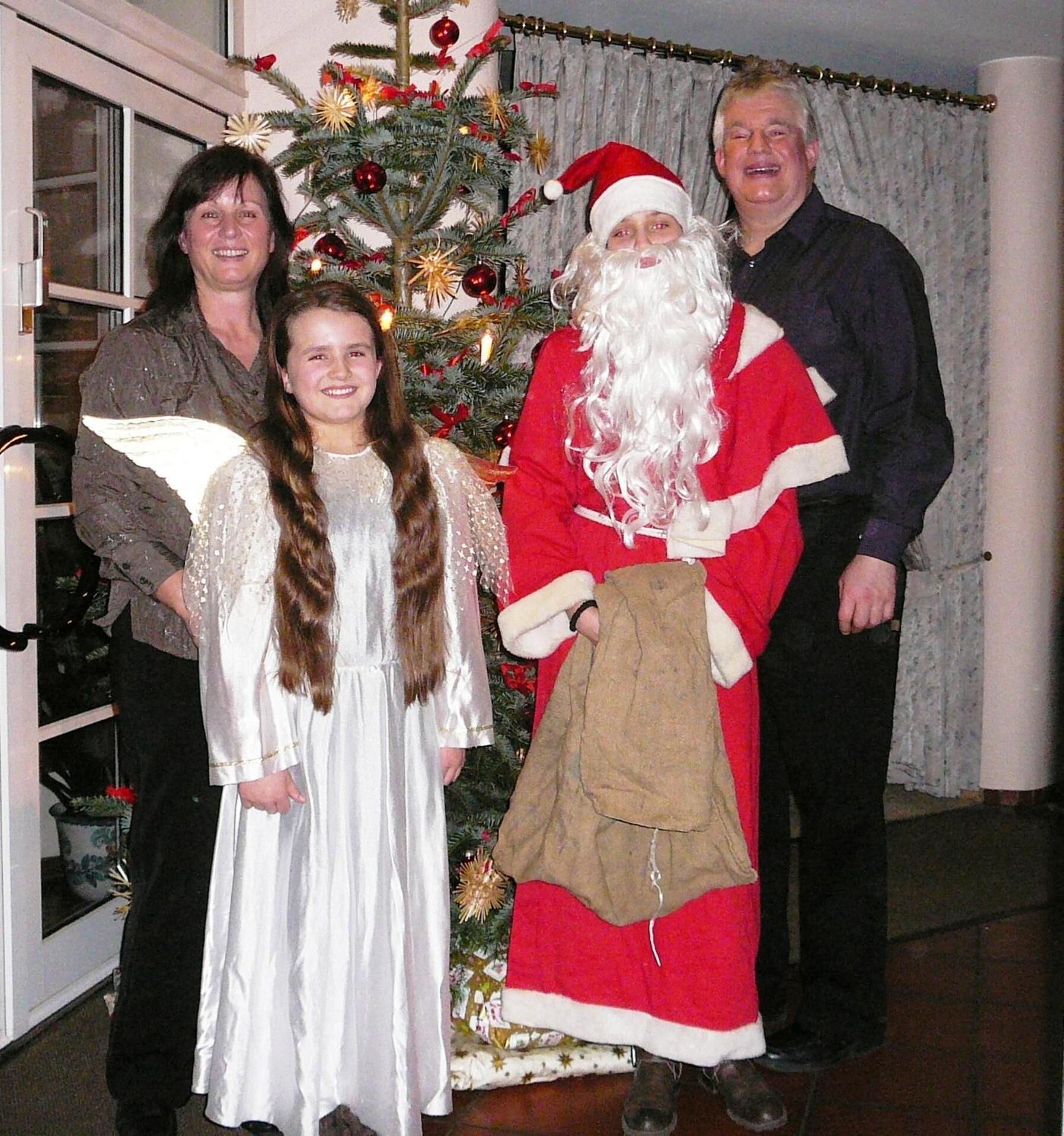 A family standing in front of a decorated Christmas tree.